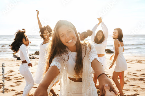 Group of diverse happy ladies having fun and dancing outdoors on the beach  celebrating bachelorette party on coastline