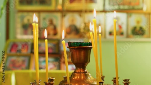 Burning candles in the temple. Christian faith in God. Saints icons. photo