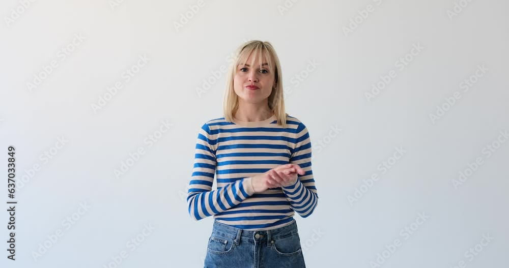 Caucasian woman is seen on a clean white backdrop, applauding with a bored expression. Her lackluster demeanor and disinterested applause indicate a sense of boredom or indifference. Caucasian woman is seen on a clean white backdrop, applauding with a bored expression. Her lackluster demeanor and disinterested applause indicate a sense of boredom or indifference.