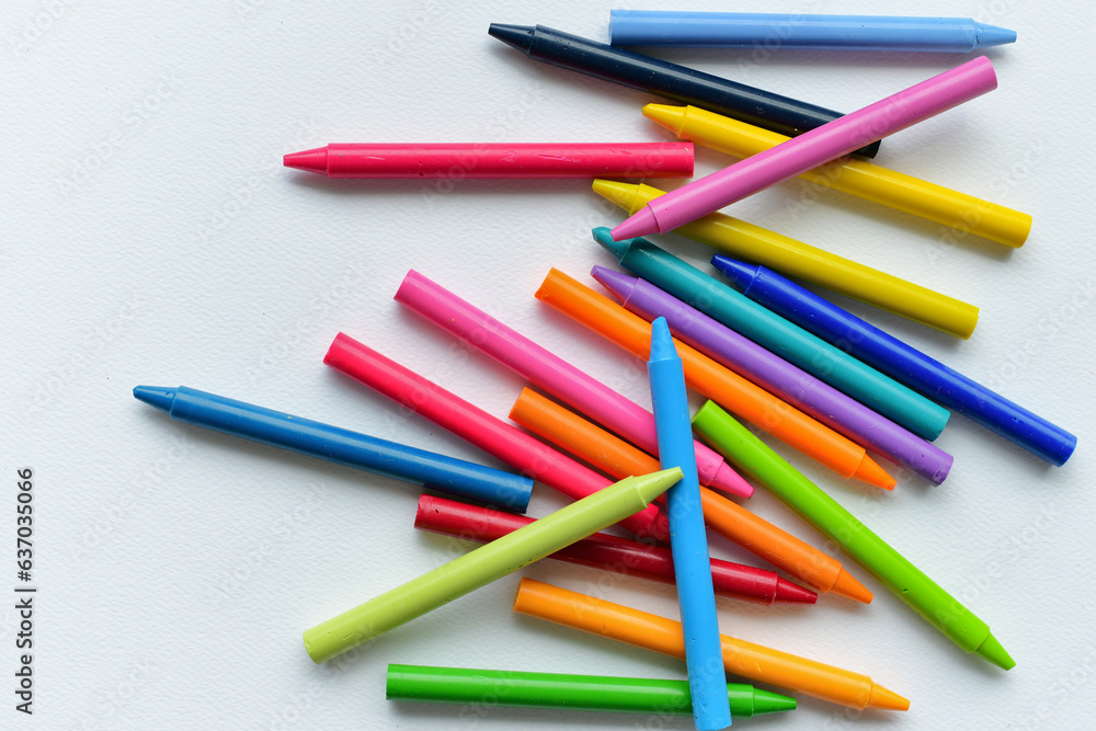 Bright colorful generic crayons on blank white paper - back to school background concept