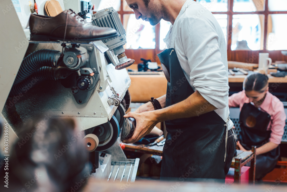 © Kzenon - Close-up of cobbler working on pair of shoes with a machine © Kzenon - Close-up of cobbler working on pair of shoes with a machine