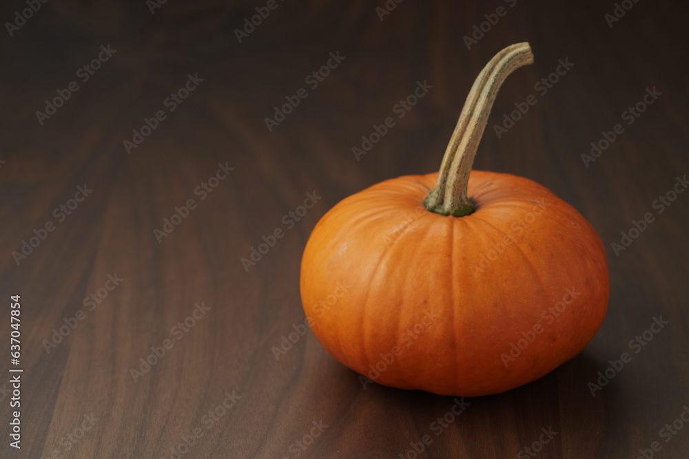 Small orange pumpkin for halloween on wood table Small orange pumpkin for halloween on wood table