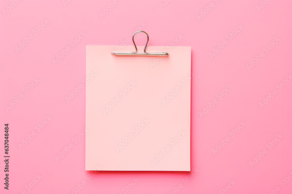 Pink sticky post it note with paper clip on pink background. Mock up of
