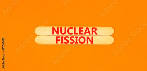Nuclear fission symbol. Concept words Nuclear fission on beautiful wooden stick. Beautiful orange table orange background. Business science nuclear fission concept. Copy space.