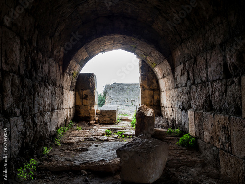 Place where a gladiator enters the amphitheater stage in the ancient city of Perge, Turkey. The walls of the corridor consist of ancient stones of kirpeches, at the exit there is an arch. No people