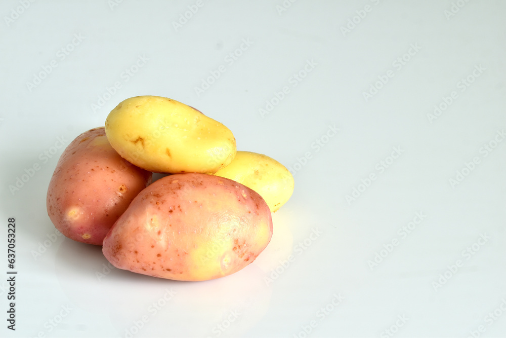 A bunch of young potatoes lie on a white background. A bunch of young potatoes lie on a white background.
