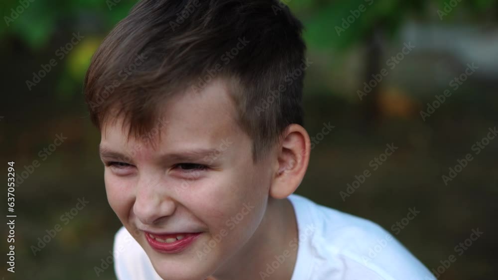 a ten-year-old boy laughs on the street. close-up portrait. a ten-year-old boy laughs on the street. close-up portrait.