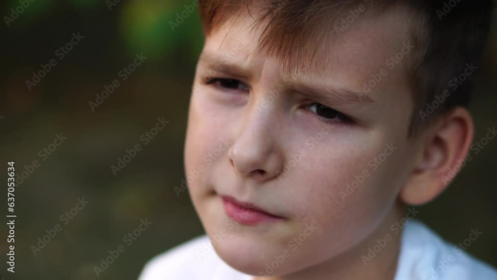 sad calm boy sits alone in the park. close-up portrait. sad calm boy sits alone in the park. close-up portrait.
