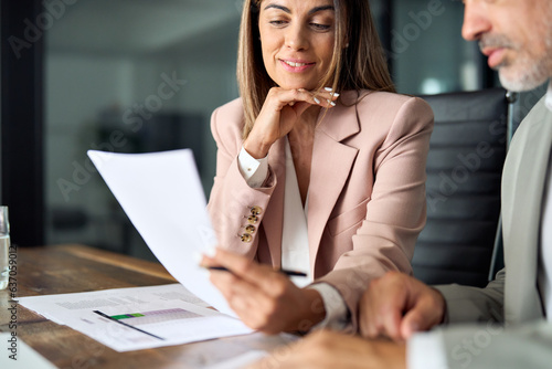 Business woman lawyer attorney showing document to man client providing advisory services, professionals discussing tax papers working in office at meeting. Legal consultancy concept. Close up.