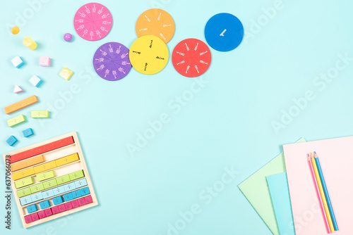 Education, mathematics learning concept. School supplies and colorful math fractions, cubes on light blue background. Top view, copy space