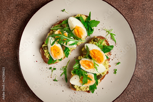 sandwich with mashed avocado, boiled egg, and arugula, on bread , homemade, breakfast,
