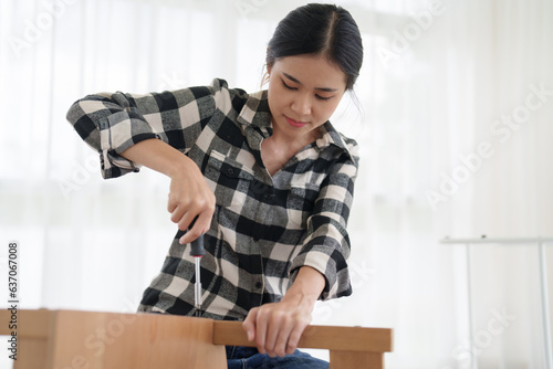 Foto asian female assembly of furniture with hand tools at home .