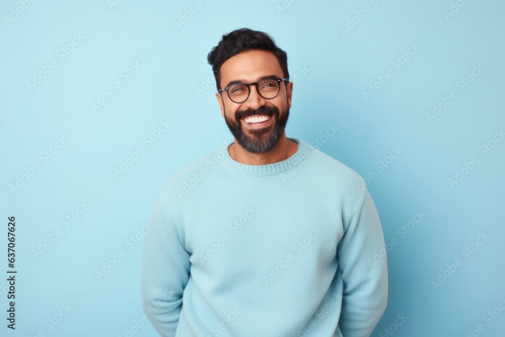 happy indian man with eyeglasses looking at camera over blue background happy indian man with eyeglasses looking at camera over blue background