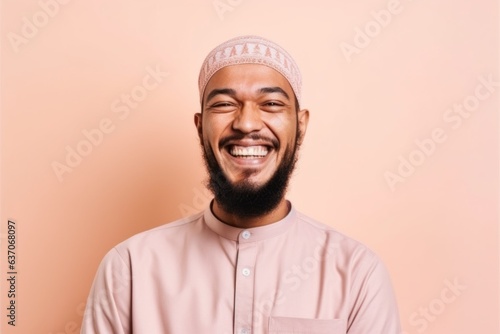 Portrait of a happy muslim man smiling isolated over pink background