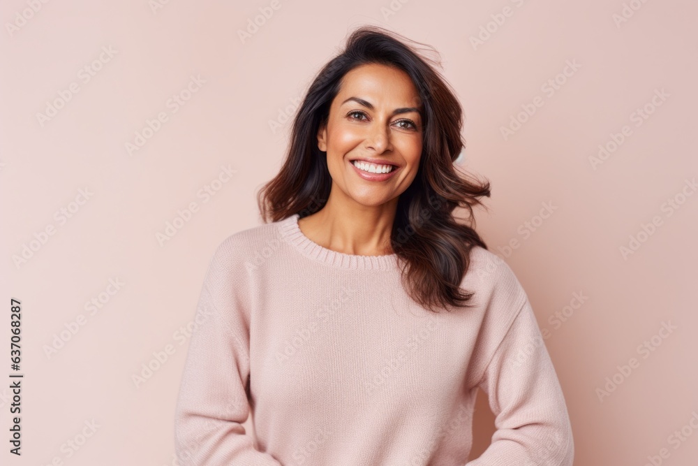 Portrait of a beautiful young woman smiling at the camera on a pink background