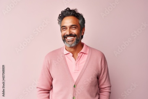 Portrait of a happy Indian man smiling at camera over pink background