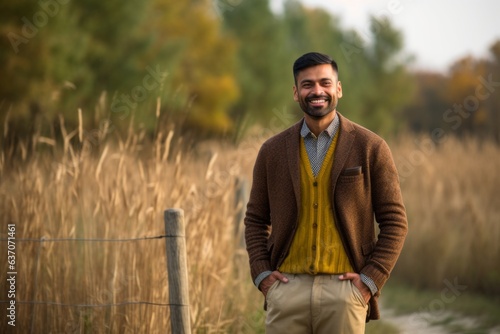 Portrait of handsome bearded Indian man in a wheat field in autumn