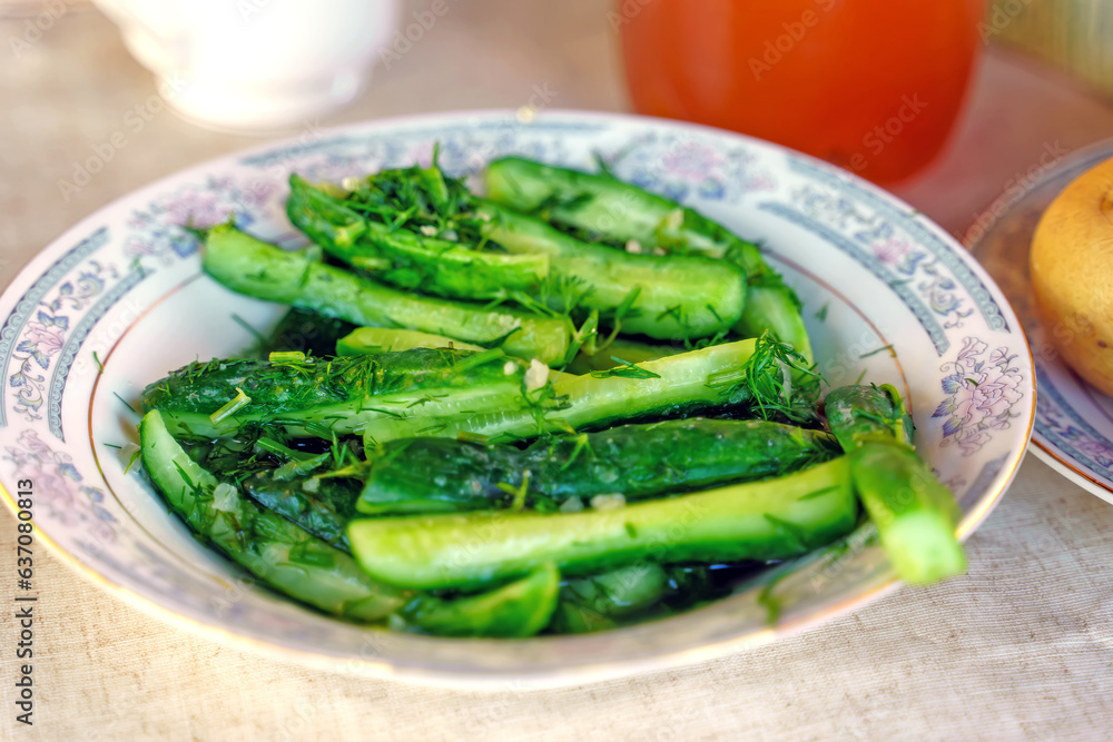 Sliced lightly salted cucumbers sprinkled with dill on a plate Sliced lightly salted cucumbers sprinkled with dill on a plate