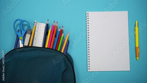 From the school bag appear books, scissors, pencils and ruler. A blank sheet with a pen. Place for inscription. Stop motion