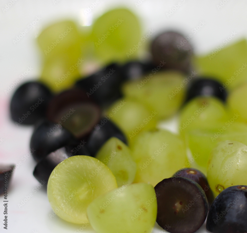 Obraz premium green and black grapes. cut grapes ready for consumption. grapes with selective focus.