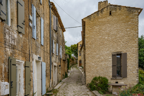 A beautiful narrow street between old country houses built of decaying bricks and stones. © Tomasz