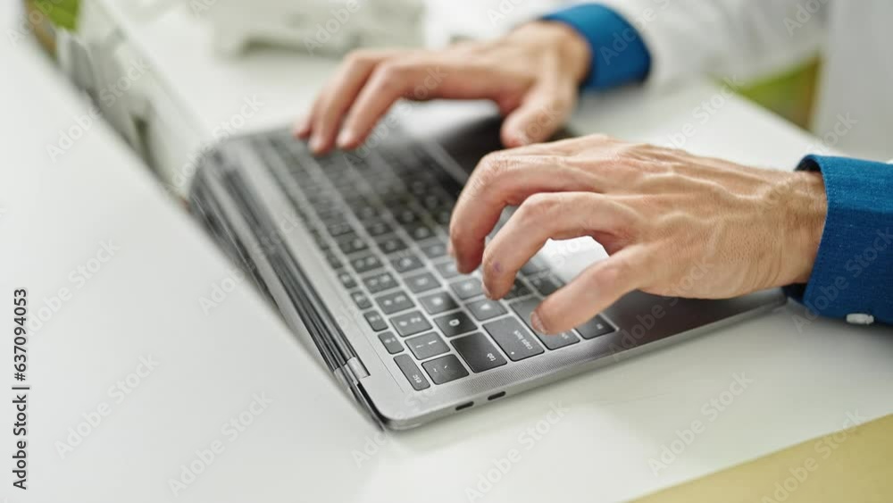 Young hispanic man doctor typing on laptop at the clinic Young hispanic man doctor typing on laptop at the clinic