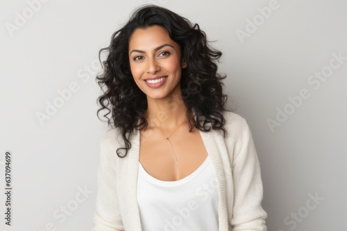 Medium shot portrait of an Indian woman in her 30s against a white background