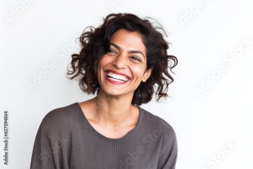 Lifestyle portrait of an Indian woman in her 30s against a white background
