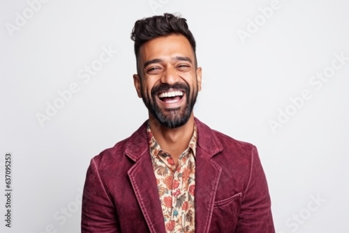 Medium shot portrait of an Indian man in his 30s against a white background