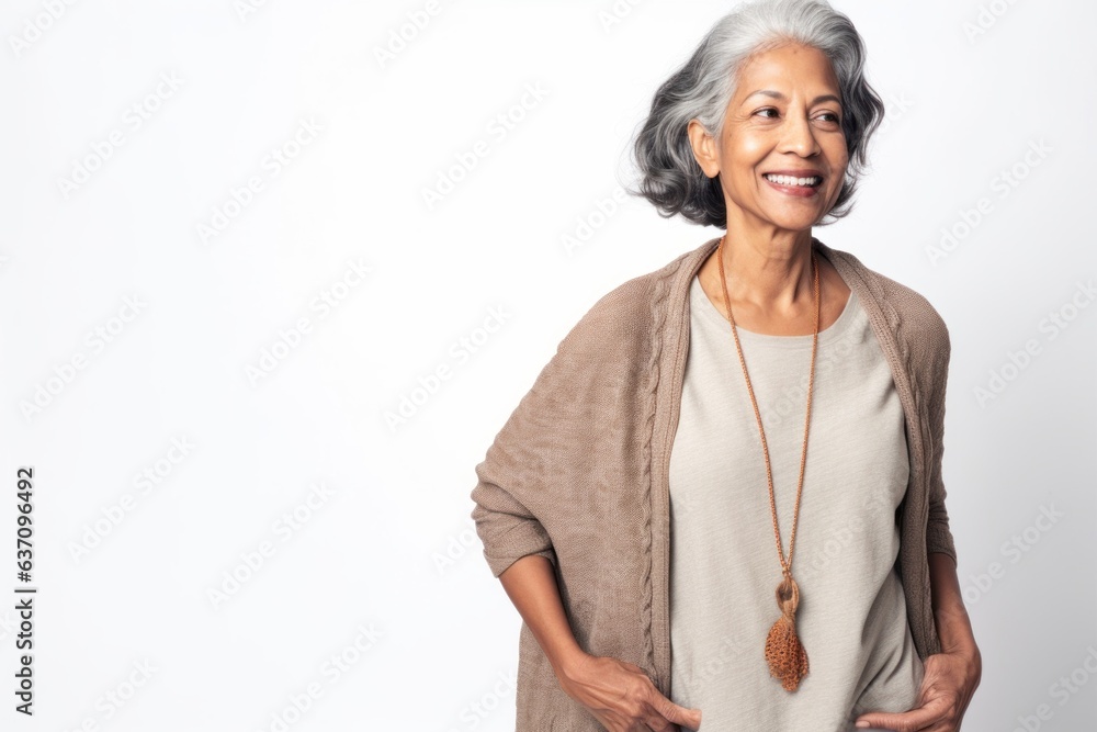 Lifestyle portrait of an Indian woman in her 50s against a white background Lifestyle portrait of an Indian woman in her 50s against a white background