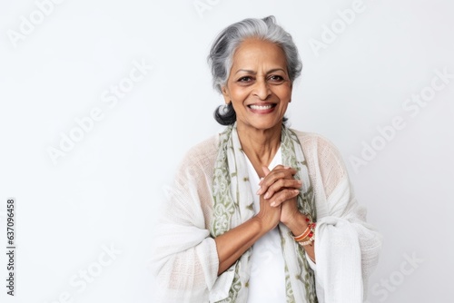 Medium shot portrait of an Indian woman in her 50s against a white background © Eber Braun