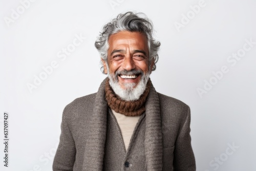 Medium shot portrait of an Indian man in his 60s against a white background