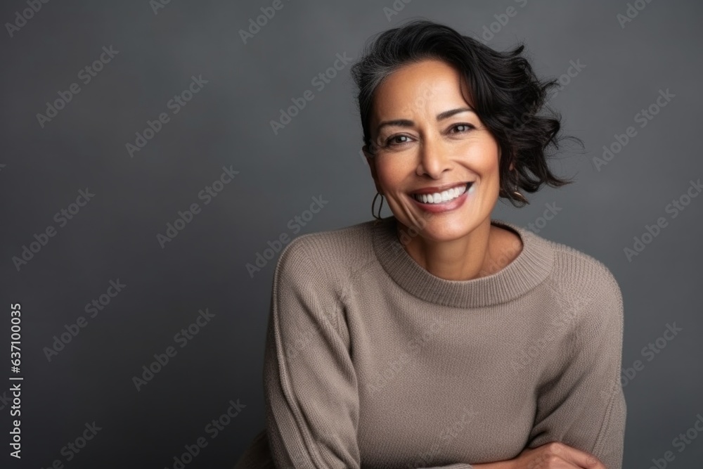 Medium shot portrait of an Indian woman in her 40s in a minimalist background Medium shot portrait of an Indian woman in her 40s in a minimalist background