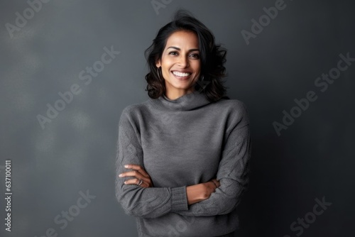 Medium shot portrait of an Indian woman in her 40s in a minimalist background