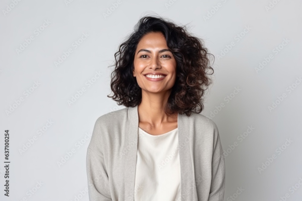 Medium shot portrait of an Indian woman in her 40s in a minimalist background Medium shot portrait of an Indian woman in her 40s in a minimalist background