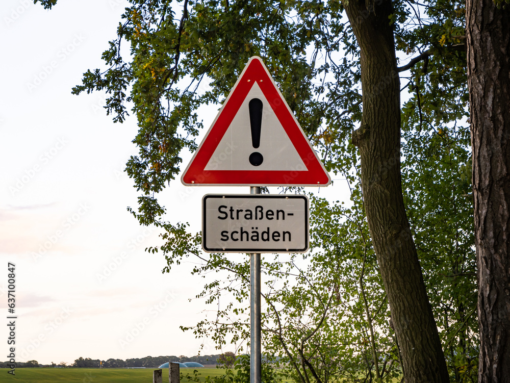 Straßenschäden (road damaged) traffic sign with a big exclamation mark. Warning for car drivers in Germany that there are bumps and potholes ahead. Straßenschäden (road damaged) traffic sign with a big exclamation mark. Warning for car drivers in Germany that there are bumps and potholes ahead.