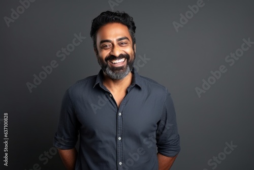 Medium shot portrait of an Indian man in his 40s in a minimalist background