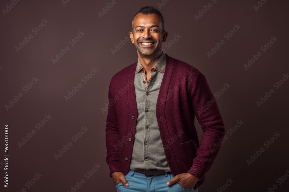 Obraz premium Lifestyle portrait of an Indian man in his 40s in a minimalist background