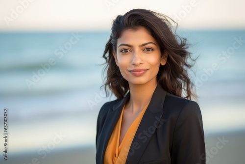 Group portrait of an Indian woman in her 30s wearing a sleek suit in a beach 