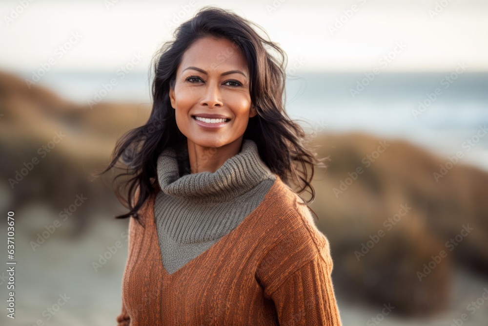 Lifestyle portrait of an Indian woman in her 40s in a beach