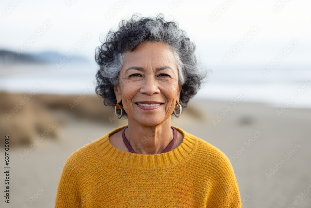 Portrait of senior woman smiling at camera on beach during autumn day Portrait of senior woman smiling at camera on beach during autumn day
