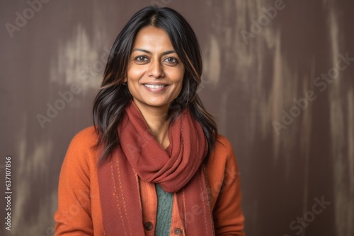Lifestyle portrait of an Indian woman in her 40s in an abstract background