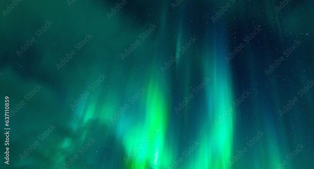 Beautiful night sky filled with an array of vibrant green northern lights or aurora borealis