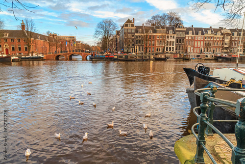 Cityscape on a sunny winter day - view of the Amstel river in the historic center of Amsterdam, The Netherlands