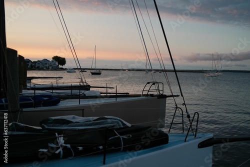 View of a sailboat deck at sunrise  with the sun reflecting off the tranquil waters of the ocean