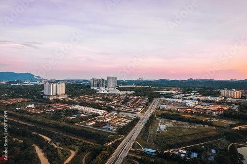Aerial view of a highway in a green city at sunset
