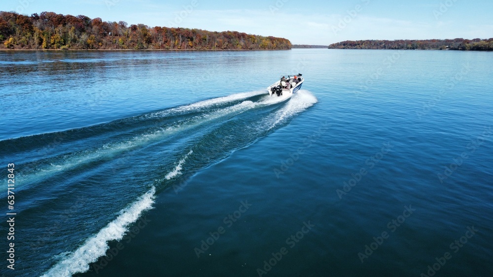 Obraz premium Aerial view of a motorboat sailing in the sea near the shore on a sunny day