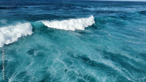 Aerial view of turquoise waves in the sea on a sunny day