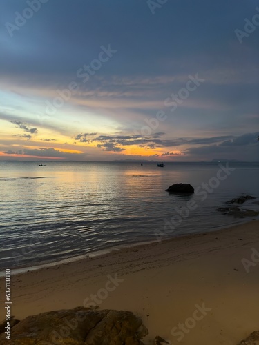 Tranquil beach scene with a picturesque sunset illuminating the horizon