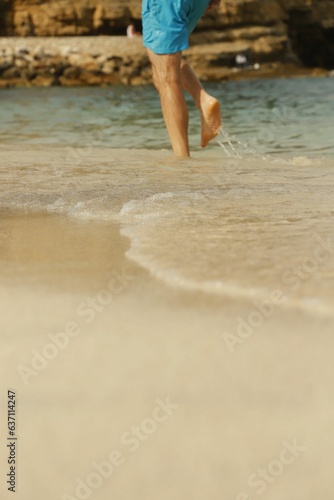 Male walking on the beach shore © Alberto Dumont Guillen/Wirestock Creators